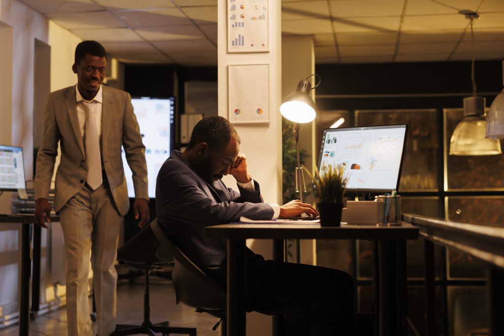 manager wakes up employee after falling asleep on table desk